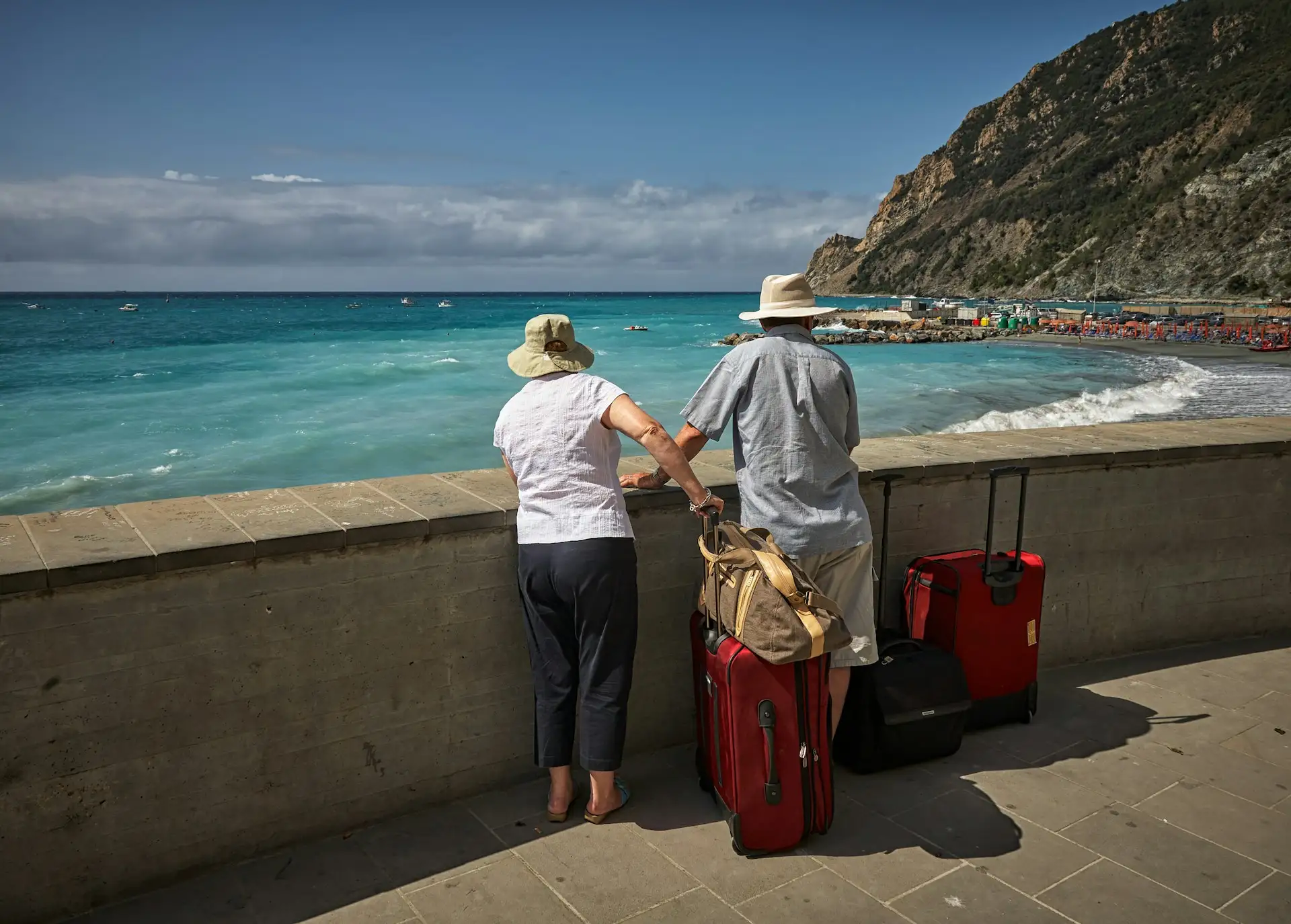 Parents enjoying a relaxing holiday by the sea with luggage